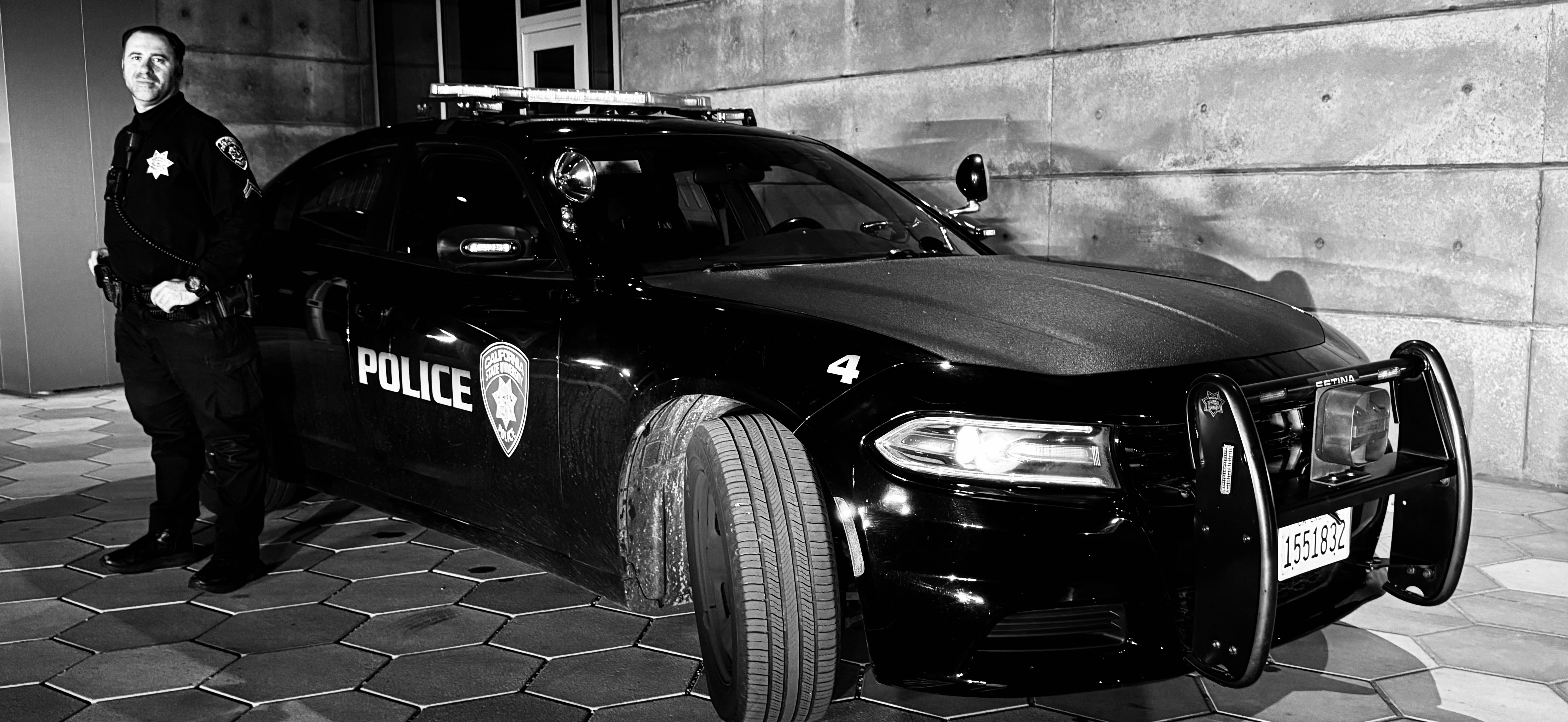 Image of an officer standing next to a police vehicle