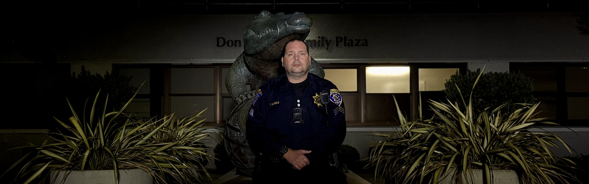 UPD officer sitting in front of the SFSU Gator statue